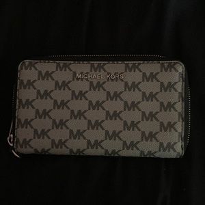A black and grey Michael Kors purse.